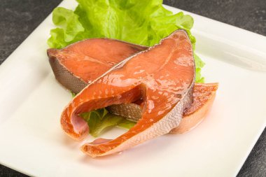 İki pembe somon balığı bifteği. Salata yaprağı.
