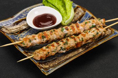 İnce kıymalı domuz şişi kebap ve bbq sosu.