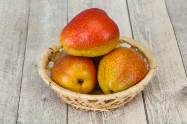 Tahta sepetteki olgun armut yığını.