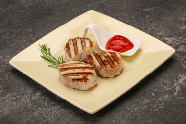 Domates soslu ızgara domuz madalyonu. Biberiye servis ediliyor.