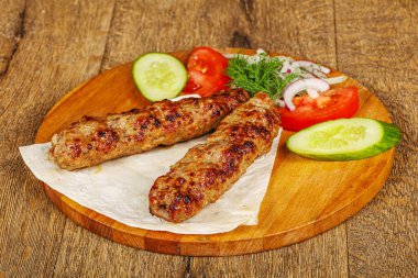 Biftek dilimlenmiş et shashlik sebze servis ediyordu.