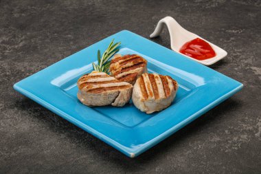 Domates soslu ızgara domuz madalyonu. Biberiye servis ediliyor.