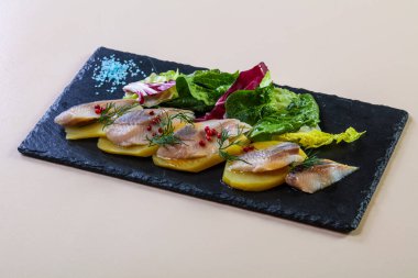 Patates ve soğanlı ringa balığı.