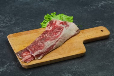 Tahtanın üzerinde çiğ domuz pastırması salata ve kekik servis edildi.