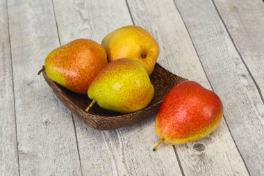 Tahta sepetteki olgun armut yığını.