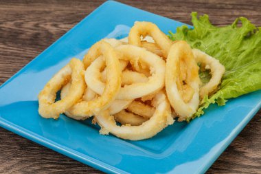 Kavrulmuş kalamar halkaları ve kasede salata.