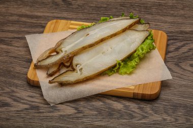 Lezzetli füme halibut balığı aperatifi keser.