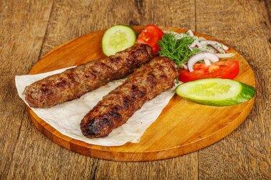 Biftek dilimlenmiş et shashlik sebze servis ediyordu.