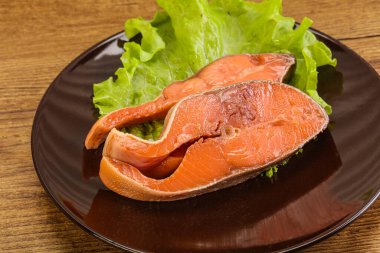 İki pembe somon balığı bifteği. Salata yaprağı.