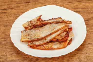 Kızarmış domuz pastırması tabakta.