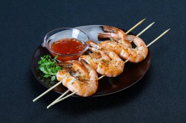 Baharatlı soslu ızgara karides şişi.