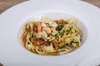 İtalyan spagettisi, deniz ürünleri ve bitkilerle.