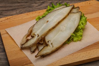 Lezzetli füme halibut balığı aperatifi keser.