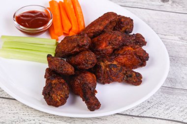 Tavuk kanatları kereviz ve havuç dilimli.