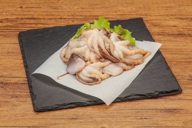 Çiğ deniz ürünleri - ahtapot tahtada pişirmek için.