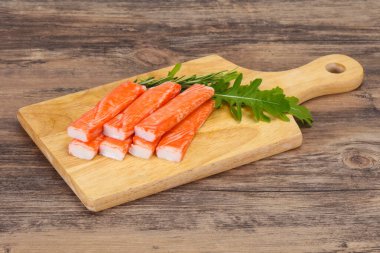 Ahşap tahtanın üzerinde yengeç çubuğu surimi