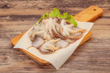 Çiğ deniz ürünleri - ahtapot tahtada pişirmek için.