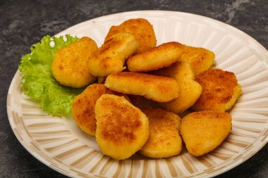 Kızarmış tavuk nugget. Salata yaprakları.