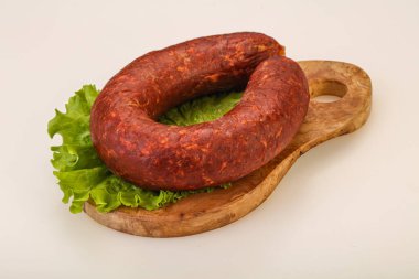 Tahtanın üzerinde Krakowska sosisi otlar ve baharatlarla