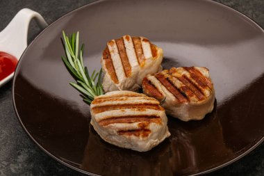 Domates soslu ızgara domuz madalyonu. Biberiye servis ediliyor.