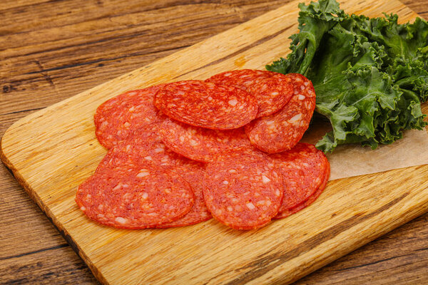 Italian spycy pepperoni sausage slices over board
