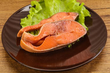 İki pembe somon balığı bifteği. Salata yaprağı.