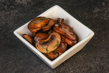 Kavrulmuş şampiyon, kasede otlar ve baharatlar var.