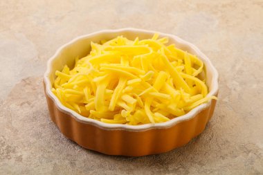 Yemek pişirmek için kasede dilimlenmiş sarı peynir.