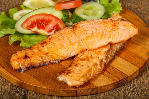 Izgara somon, sebze ve limon dilimi.