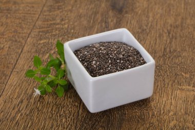 Tahta arka planda diyet Chia tohumları var.