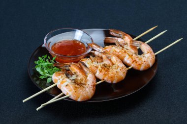 Baharatlı soslu ızgara karides şişi.