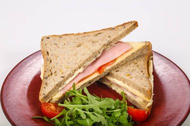 Jambonlu ve peynirli sandviç roka servis edildi.