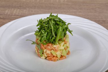 Avokado ve roka ile çiğ somon tartartarı.