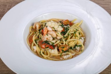 İtalyan spagettisi, deniz ürünleri ve bitkilerle.