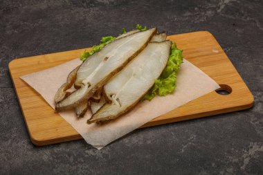 Lezzetli füme halibut balığı aperatifi keser.