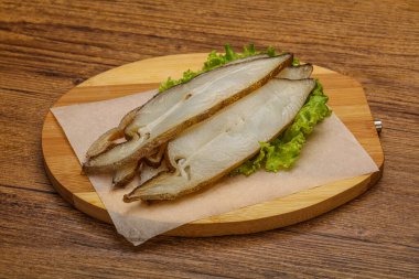 Lezzetli füme halibut balığı aperatifi keser.