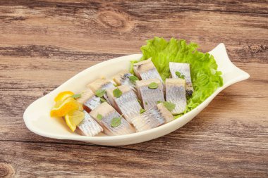 Dilimlenmiş limonla marine edilmiş ringa filetosu.