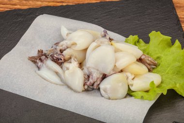 Çiğ deniz ürünleri, güvertede pişirmek için mürekkep balığı.