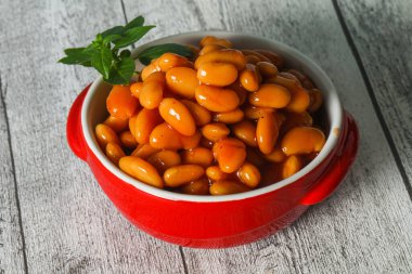 Domates soslu beyaz fasulye fesleğen yaprağı servis etti.