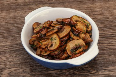 Kavrulmuş şampiyon, kasede otlar ve baharatlar var.