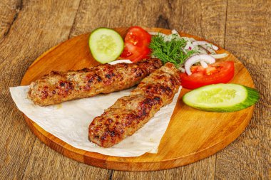 Biftek dilimlenmiş et shashlik sebze servis ediyordu.