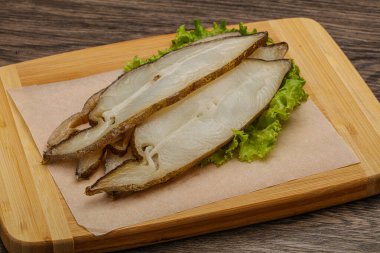 Lezzetli füme halibut balığı aperatifi keser.