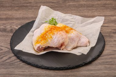 Kızartma için baharatlı çiğ tavuk budu.