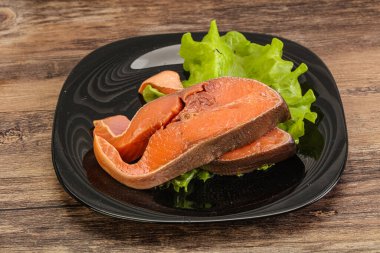 İki pembe somon balığı bifteği. Salata yaprağı.