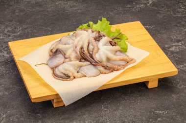 Çiğ deniz ürünleri - ahtapot tahtada pişirmek için.