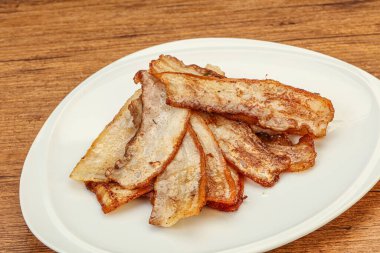 Kızarmış domuz pastırması tabakta.