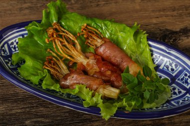 Kızarmış enoki mantarı ve domuz pastırması fesleğen yaprağı.