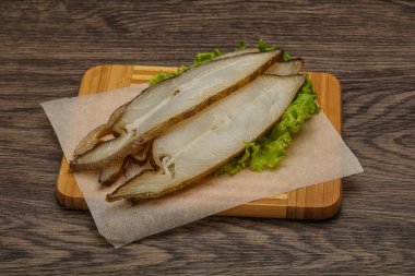 Lezzetli füme halibut balığı aperatifi keser.