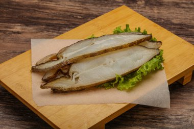 Lezzetli füme halibut balığı aperatifi keser.