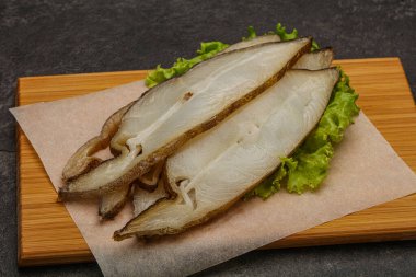 Lezzetli füme halibut balığı aperatifi keser.